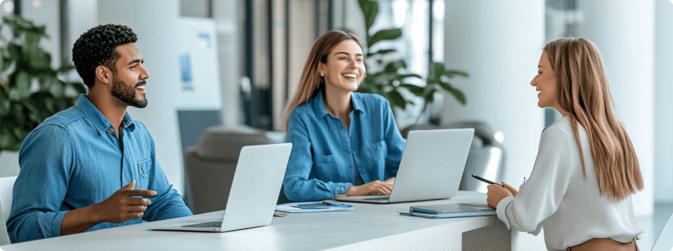 three people working together on a laptop in an office
