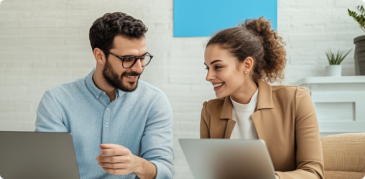 two people working together on a laptop in an office